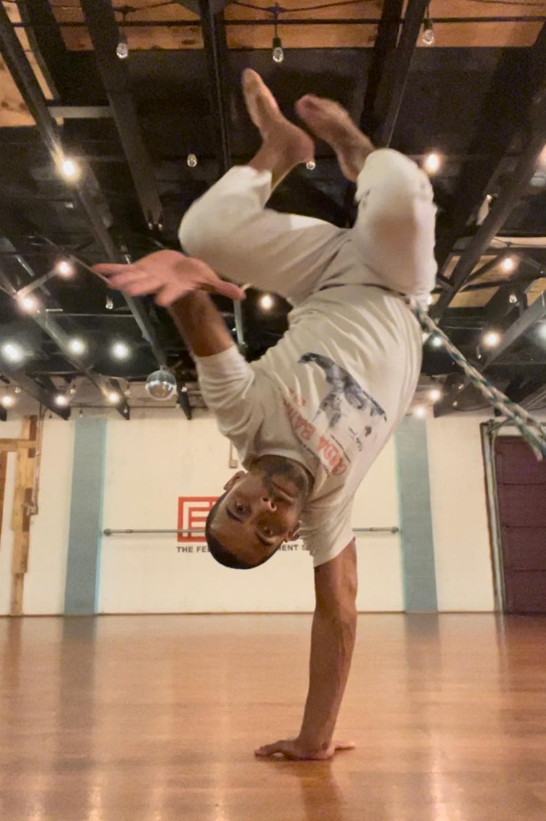 Capoeirista holding a one-handed handstand (au)